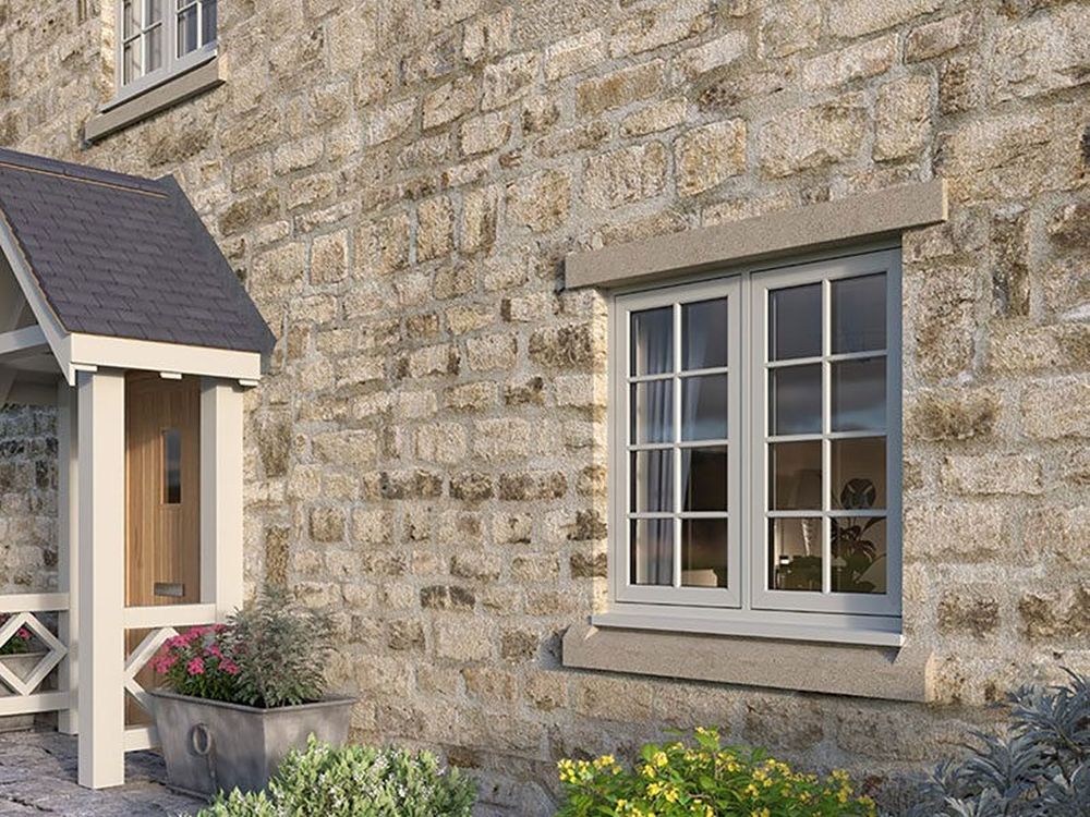 A stone house featuring a front door, porch, and a window